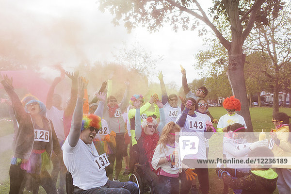 Playful runners throwing holi powder at charity run in park
