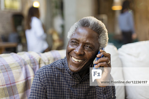 Lächelnder älterer Mann spricht auf dem Smartphone