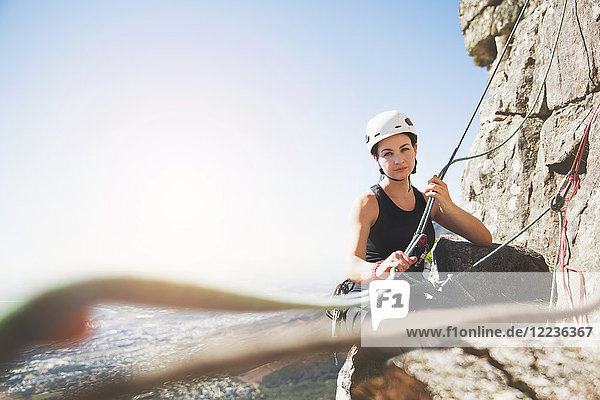 Portrait confident female rock climber with ropes