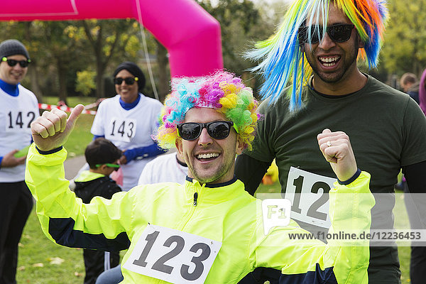 Portrait enthusiastic male runners wearing wigs at charity run