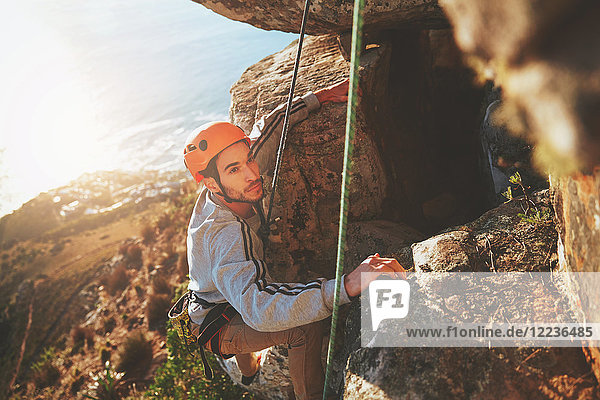 Fokussierter männlicher Kletterer Kletterfelsen