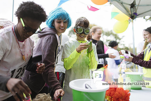 Runners with wig and holi powder at charity run tent