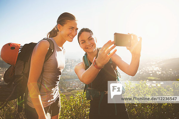 Female rock climbers taking selfie with camera phone