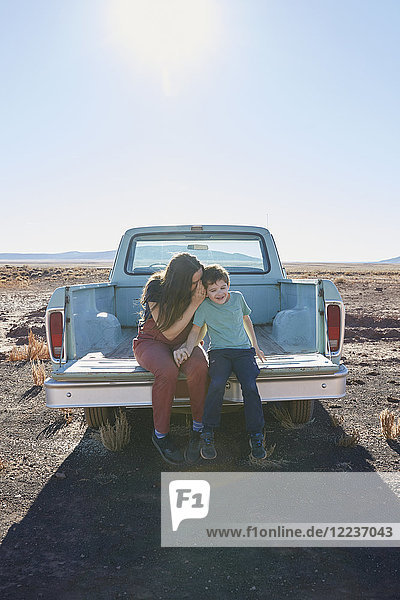 USA  Arizona  Mutter mit Sohn (6-7) auf der Heckklappe eines Pick-up-Trucks sitzend