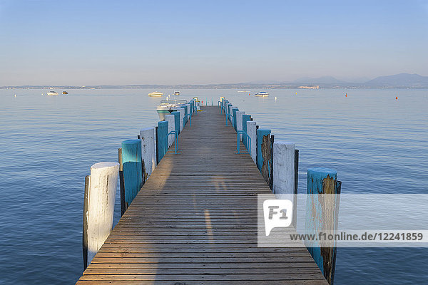 Wooden jetty on Lake Garda (Lago di Garda) in the morning at Bardolino in Veneto  Italy