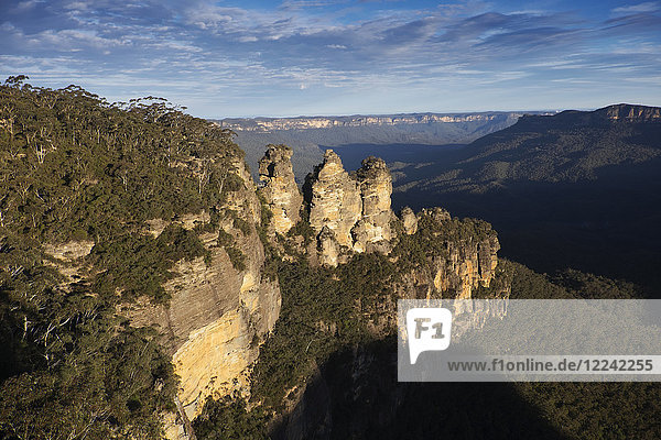 Sunlight reflecting on the Three Sisters rock formations and scenic view of the Blue Mountains National Park in New South Wales  Australia