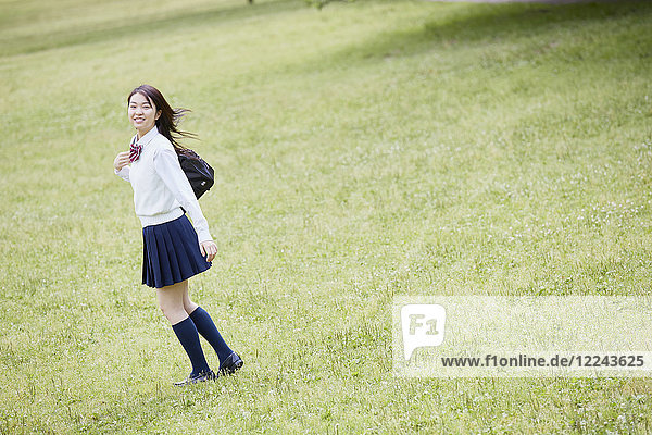 Niedliche japanische Oberschülerin in einem Stadtpark