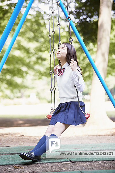 Cute Japanese high school student in a city park