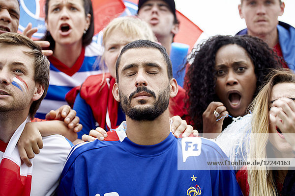 Französische Fußballfans schauen schockiert und enttäuscht über das Spiel