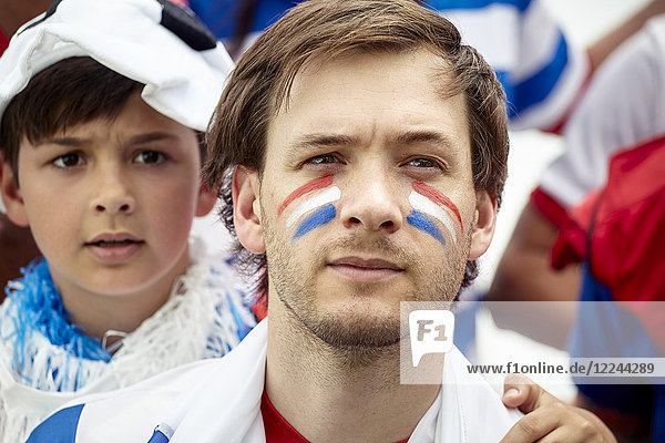 Vater und Sohn beobachten ängstlich das französische Fußballspiel