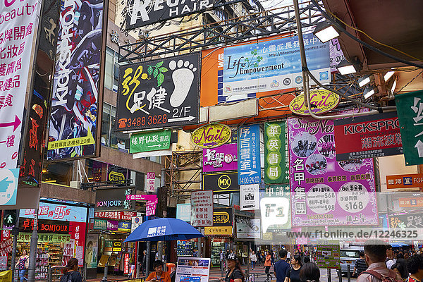Advertising signs on a busy street in the popular shopping area of Mong Kok (Mongkok)  Kowloon  Hong Kong  China  Asia