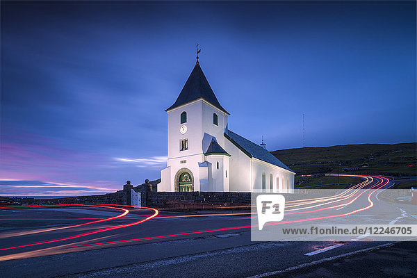 Lichter von Autospuren an der Kirche von Eidi in der Abenddämmerung  Eysturoy Island  Färöer Inseln  Dänemark  Europa