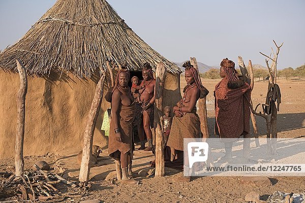 Himba women with small children in front of their hut  Kaokoveld  Namibia  Africa