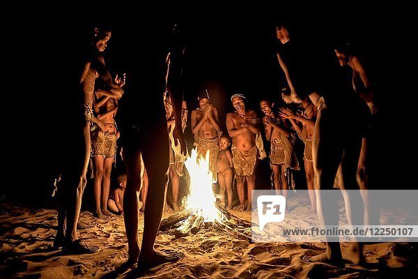 Bushmen of the Ju/' Hoansi-San stand by the campfire  village //Xa/oba  near Tsumkwe  Otjozondjupa region  Namibia  Africa