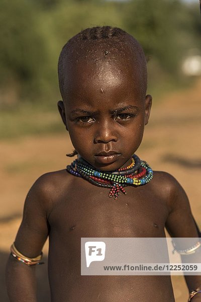 Kleines Mädchen  ernster Blick  mit Fliege am Auge  Porträt  Stamm der Hamer  Turmi-Markt  Region der südlichen Nationen und Völker  Äthiopien  Afrika
