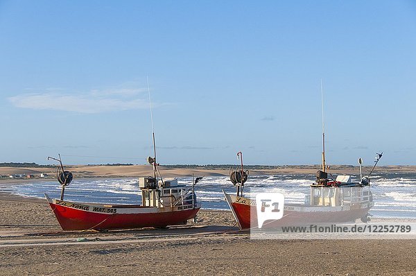 Zwei rote Fischerboote liegen am Strand des Atlantischen Ozeans  Dorf Cabo Polonio  Cabo Polonio Nationalpark  Provinz Rocha  Uruguay  Südamerika