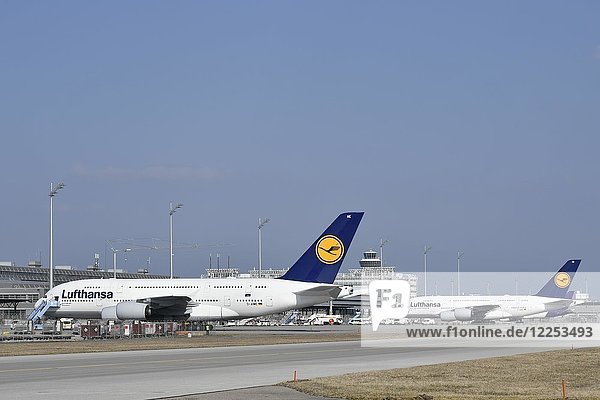 Zwei Airbus  A380-800  Lufthansa  in Parkposition  mit Tower  Flughafen München  Oberbayern  Bayern  Deutschland  Europa