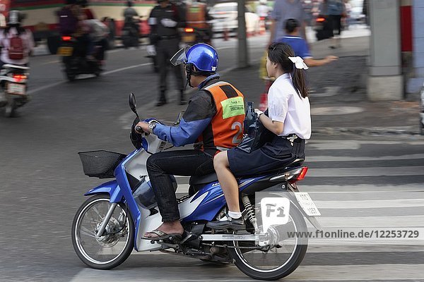 Scooter Taxi  driver with safety vest drives young girl  Sathon  Bangkok  Thailand  Asia