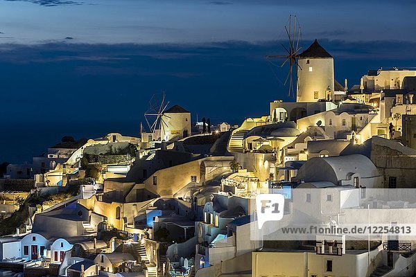 Blick auf Windmühlen und Häuser von Oia bei Nacht  Oia  Santorin  Griechenland  Europa