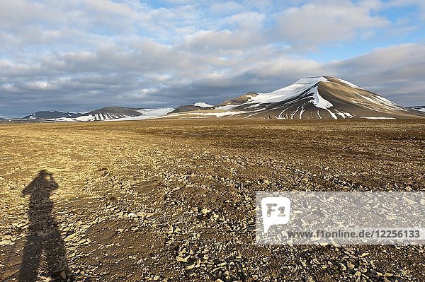 Schatten eines Menschen  polygonaler Strukturboden auf dem Platåberget  im Hintergrund der schneebedeckte Gipfel Nordenskjöldfjellet  in der Nähe von Longyearbyen  Spitzbergen  Svalbard  Norwegen  Europa
