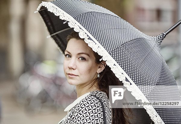 Junge Frau mit Retro-Kleid und Retro-Regenschirm  Porträt  Deutschland  Europa