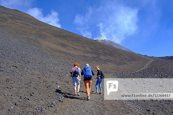 Hikers climbing through volcanic landscape  Volcano Etna  Province of Catania  Silzilia  Italy  Europe