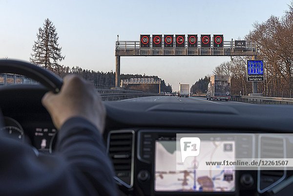 Elektronische Verkehrsschilder auf der Autobahn A9  Fahrer im Auto  Innenraum mit Navigationsgerät  Bayern  Deutschland  Europa