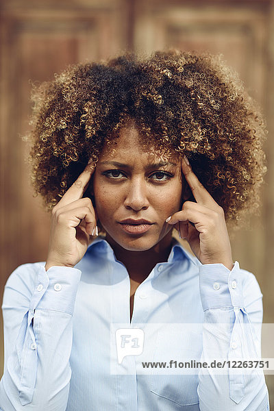 Porträt einer ernsthaften Frau mit Afro-Frisur  die im Freien denkt