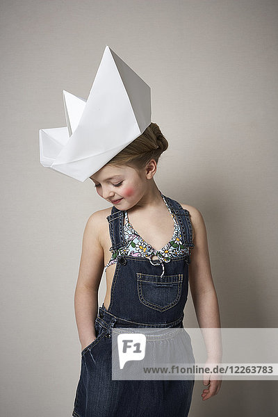 Little girl wearing big paper boat