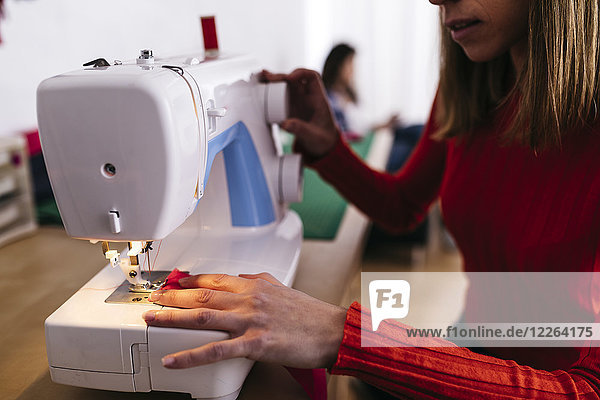 Fashion designer in studio using sewing machine