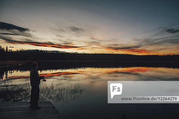 Canada  British Columbia  man fishing at Duhu Lake at sunset