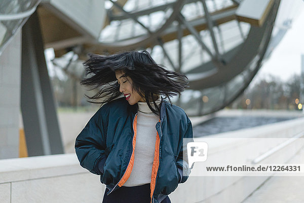 Frankreich  Paris  lächelnde junge Frau  die ihre Haare wirft