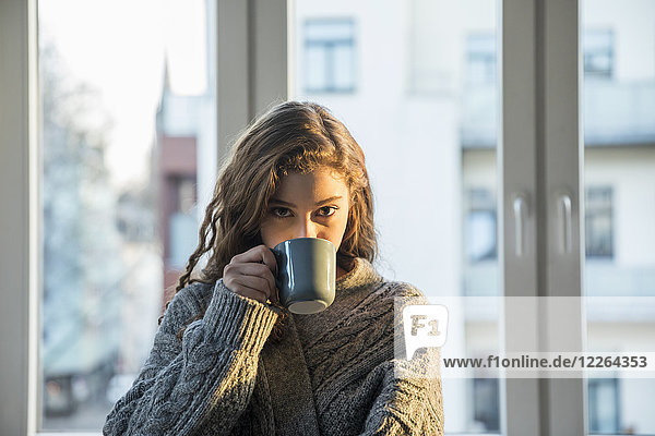 Porträt eines jungen Mädchens beim Kaffeetrinken zu Hause