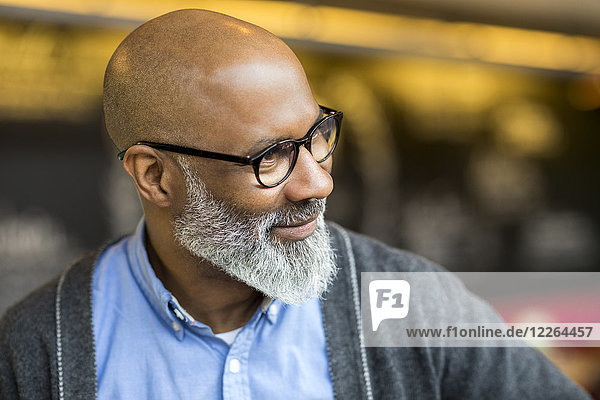 Porträt eines kahlen Mannes mit grauem Bart und Brille