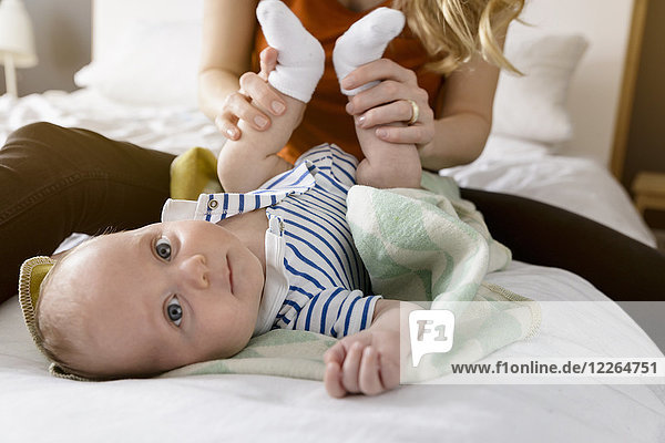 Mother playing with baby boy's feet