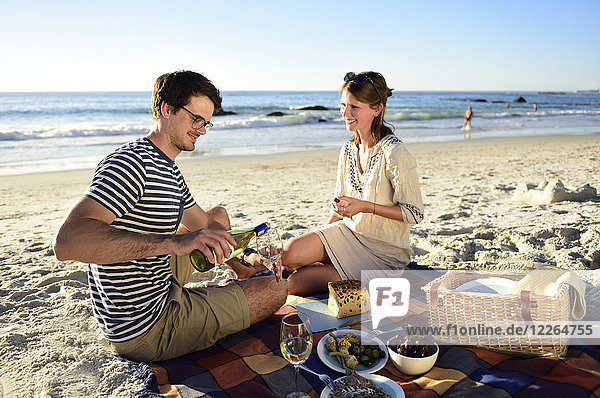 Happy couple having a picnic on the beach