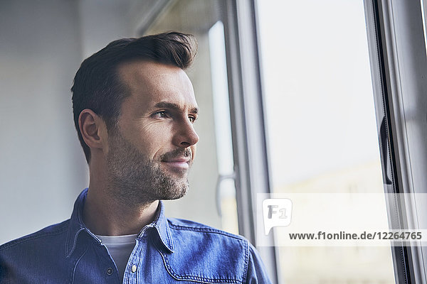 Portrait of confident man looking out of window