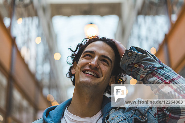 Porträt eines lächelnden jungen Mannes im Einkaufszentrum