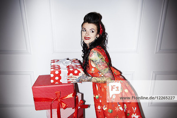 Portrait of tattooed woman with stack of gifts