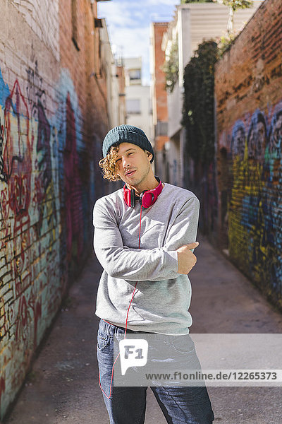 Portrait of young man with headphones wearing wool cap