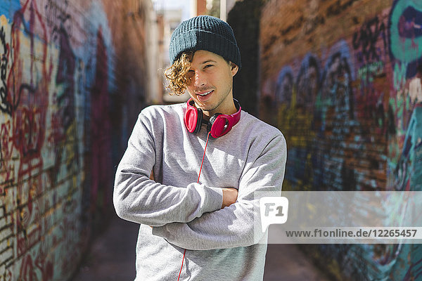 Portrait of young man with headphones wearing wool cap