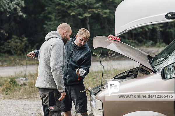 Kanada British Columbia zwei Männer kontrollieren den Ölstand des Minivans.