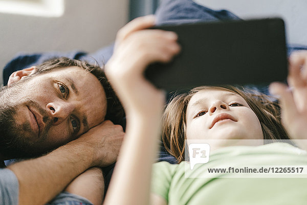 Father and son looking at smartphone together at home
