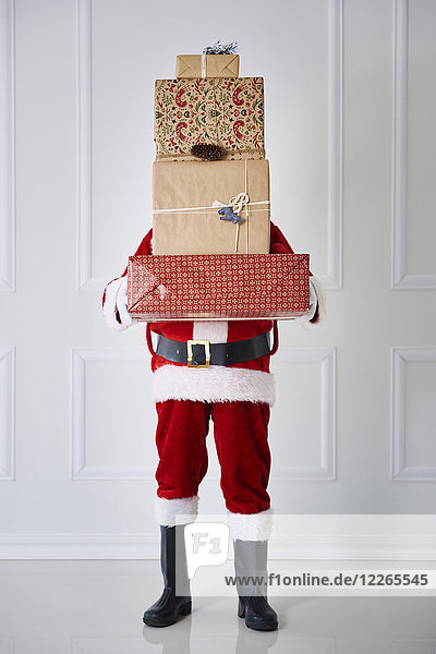Weihnachtsmann mit Weihnachtsgeschenken im Stapel