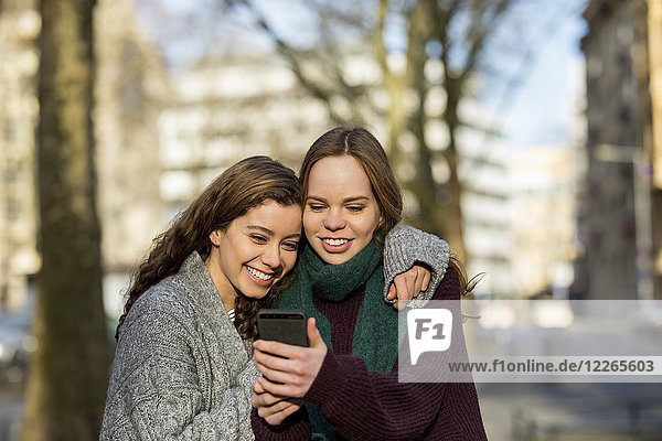 Zwei Teenager-Mädchen  die einen Selfie in der Stadt nehmen.