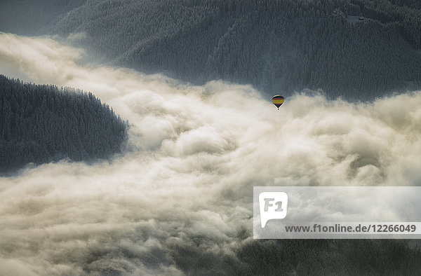 Österreich  Salzkammergut  Heißluftballon über Wolken in alpiner Landschaft