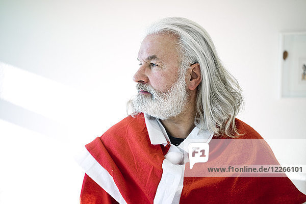 Bärtiger reifer Mann im Weihnachtsmann-Kostüm der aussieht wie der Weihnachtsmann