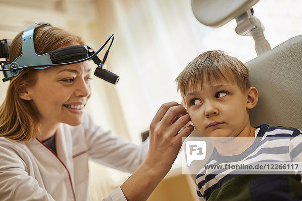 HNO-Arzt untersucht Ohr eines Jungen