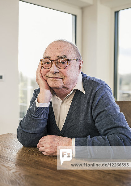 Porträt eines älteren Mannes  der am Tisch sitzt