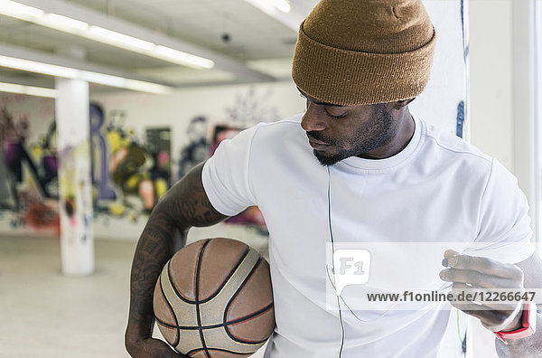Man with basketball  woolly hat and earphones